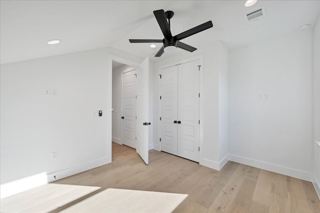 unfurnished bedroom featuring vaulted ceiling, light hardwood / wood-style floors, a closet, and ceiling fan