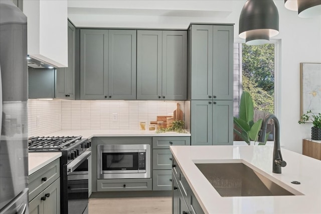 kitchen with black gas stove, sink, stainless steel microwave, and decorative backsplash