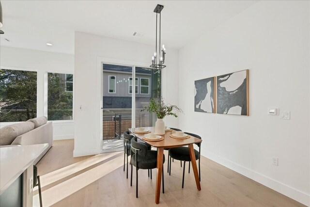 dining area with an inviting chandelier and hardwood / wood-style floors