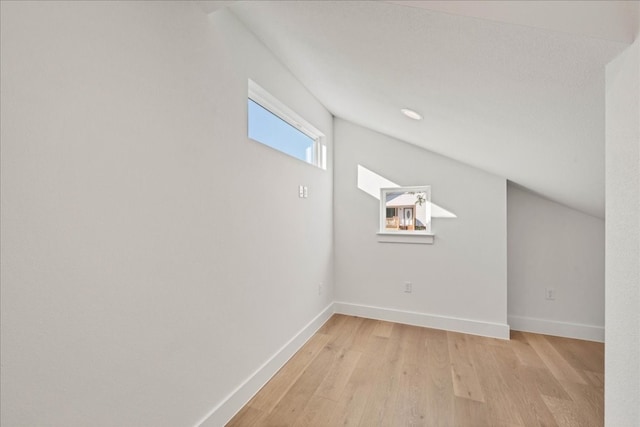 bonus room featuring lofted ceiling and light wood-type flooring