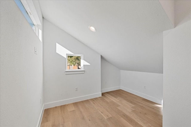 additional living space with lofted ceiling and light wood-type flooring