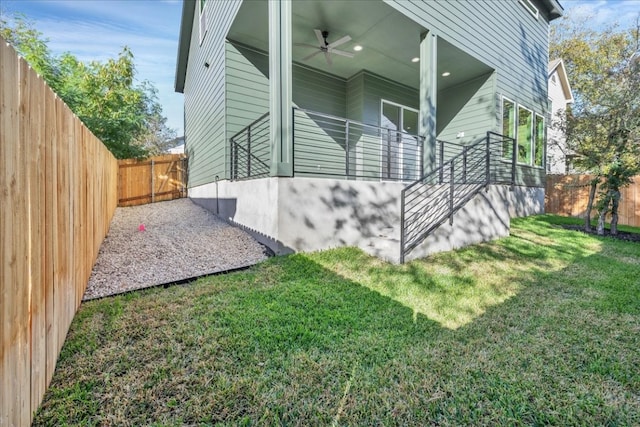 view of side of property featuring ceiling fan and a lawn