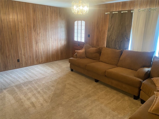 carpeted living room with wooden walls and a notable chandelier