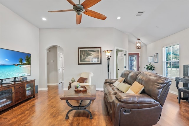 living room featuring lofted ceiling, wood-type flooring, and ceiling fan with notable chandelier