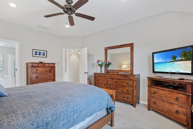 bedroom with ceiling fan, lofted ceiling, light carpet, and connected bathroom