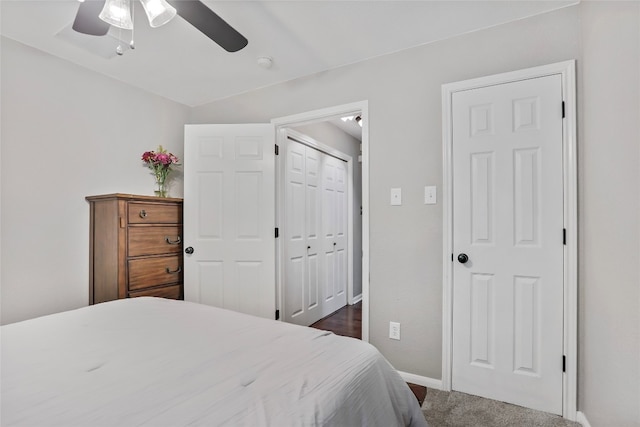 bedroom with ceiling fan, dark carpet, and a closet