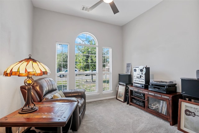 living area with ceiling fan, light colored carpet, and vaulted ceiling