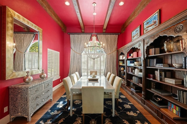 dining space featuring beam ceiling, a notable chandelier, and wood-type flooring