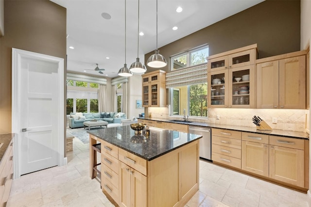 kitchen featuring ceiling fan, a center island, sink, stainless steel dishwasher, and light brown cabinetry