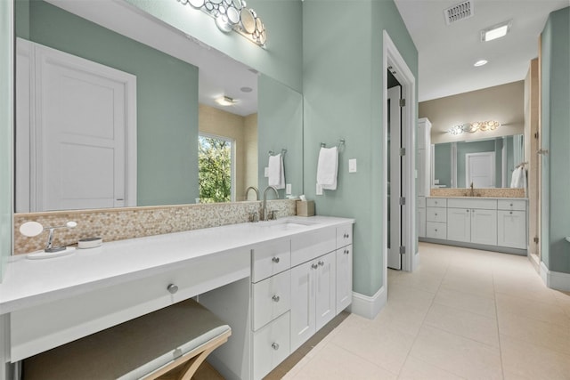 bathroom featuring tile patterned floors, vanity, and backsplash