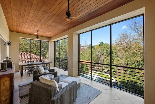 sunroom / solarium featuring wooden ceiling, ceiling fan, and a healthy amount of sunlight