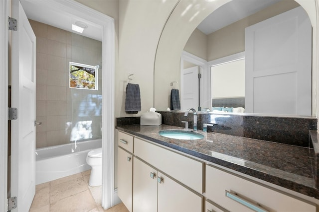 full bathroom with tile patterned floors, vanity, tiled shower / bath combo, and toilet