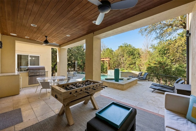 view of patio featuring area for grilling, a grill, ceiling fan, and an outdoor living space