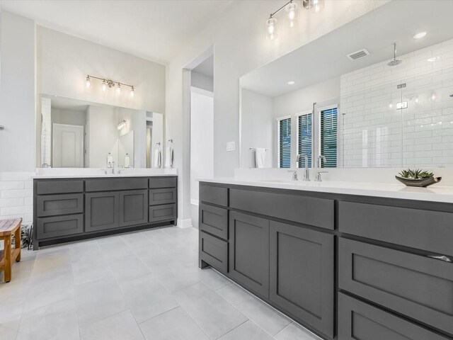 bathroom with tile patterned flooring, vanity, and a shower