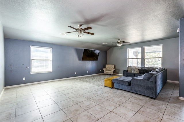 tiled living room with a textured ceiling, ceiling fan, and a healthy amount of sunlight