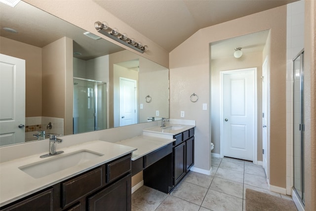 bathroom with tile patterned floors, vanity, a shower with shower door, and toilet