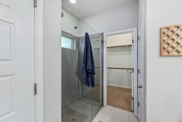 bathroom with walk in shower and tile patterned flooring