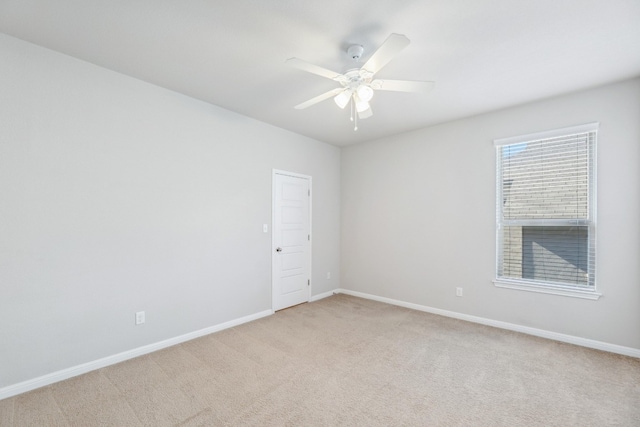 empty room with ceiling fan and light carpet