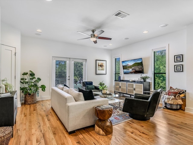 living room featuring ceiling fan, light hardwood / wood-style flooring, and french doors