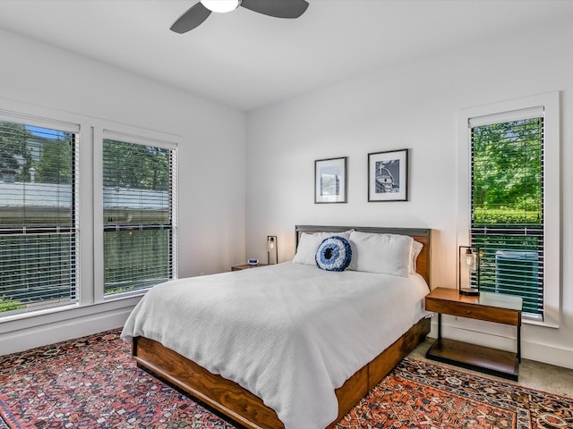 carpeted bedroom with multiple windows and ceiling fan