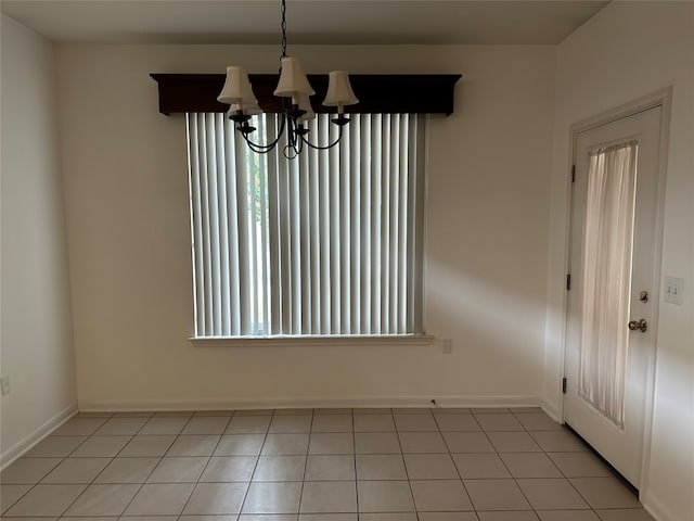 spare room featuring light tile patterned floors and a chandelier