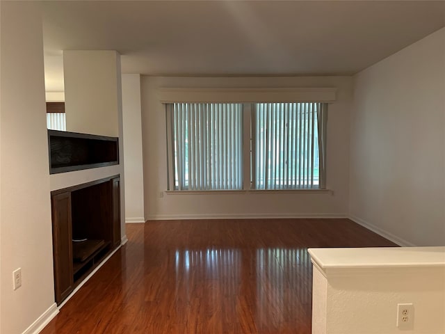 unfurnished living room featuring dark hardwood / wood-style flooring and a wealth of natural light