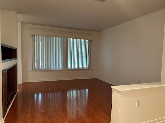 unfurnished living room featuring dark wood-type flooring