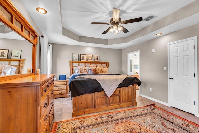 tiled bedroom featuring ceiling fan and a raised ceiling