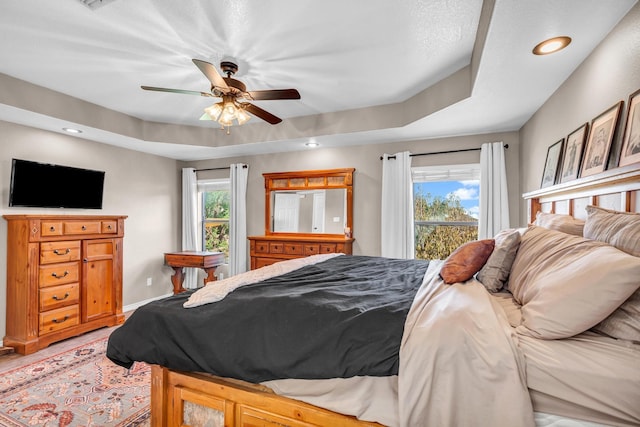 bedroom with a raised ceiling and ceiling fan