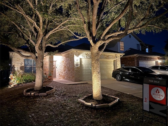 exterior space featuring a garage, driveway, and stone siding