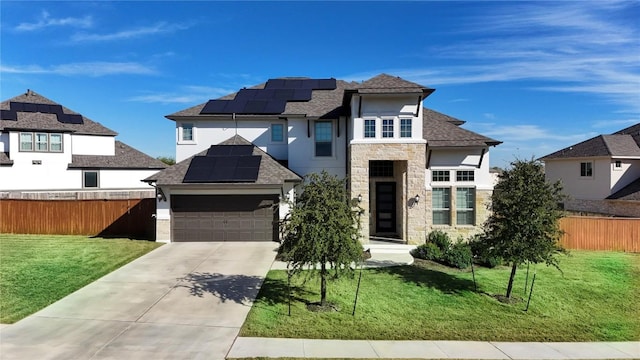 view of front of property featuring a garage, a front lawn, and solar panels