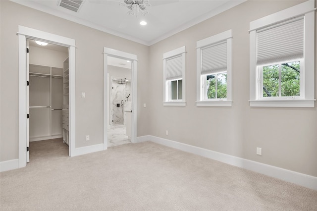 unfurnished bedroom featuring a spacious closet, ornamental molding, connected bathroom, light colored carpet, and a closet