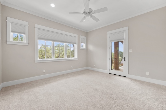 carpeted spare room featuring ceiling fan and crown molding