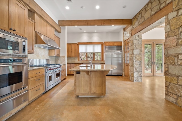 kitchen featuring french doors, beam ceiling, built in appliances, an island with sink, and range hood