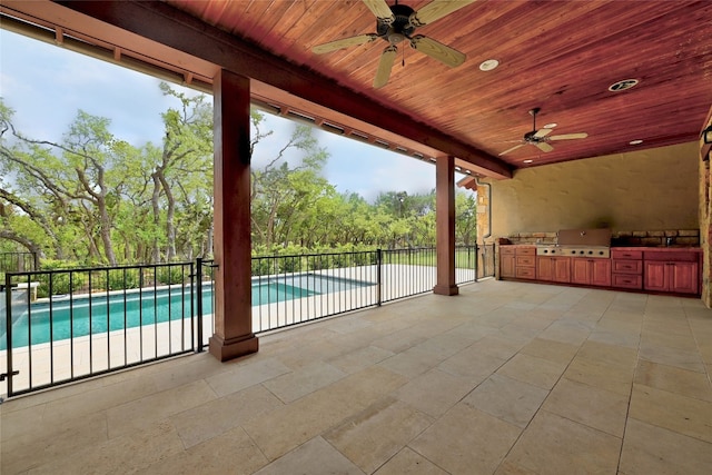 view of patio / terrace with a fenced in pool, grilling area, ceiling fan, and an outdoor kitchen