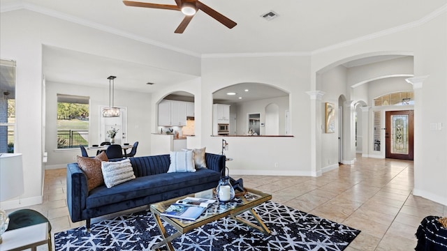 living room with ceiling fan with notable chandelier and ornamental molding