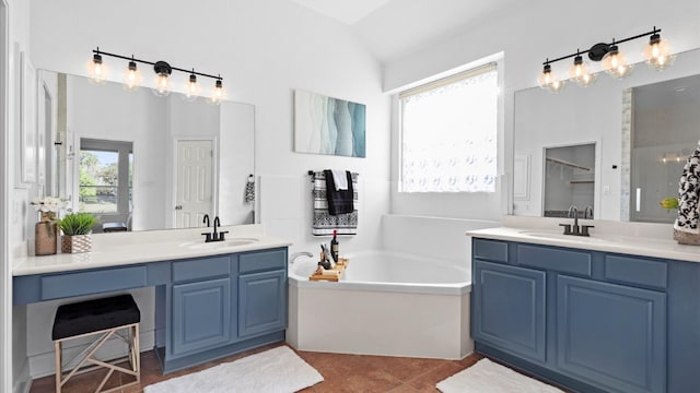 bathroom featuring tile patterned floors, a tub, a wealth of natural light, and vanity