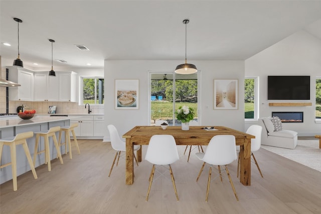 dining space featuring sink, plenty of natural light, and light wood-type flooring