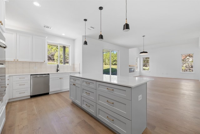 kitchen with dishwasher, pendant lighting, light hardwood / wood-style flooring, and a wealth of natural light