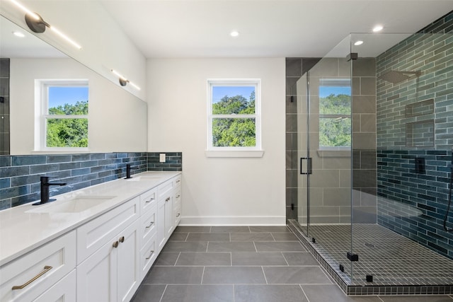 bathroom featuring tile patterned floors, vanity, a healthy amount of sunlight, and a shower with shower door