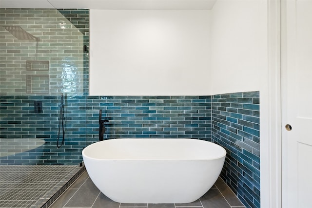 bathroom with tile patterned floors, a tile shower, and tile walls