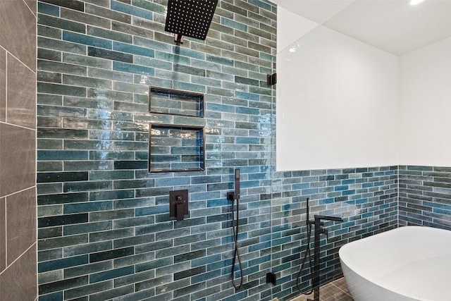 bathroom featuring shower with separate bathtub and tile walls