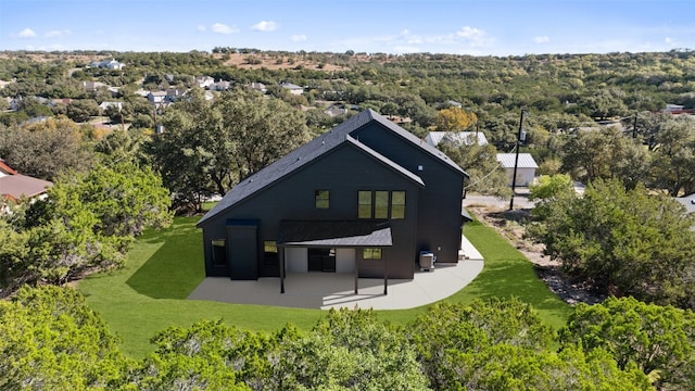 back of property featuring a lawn and a patio area