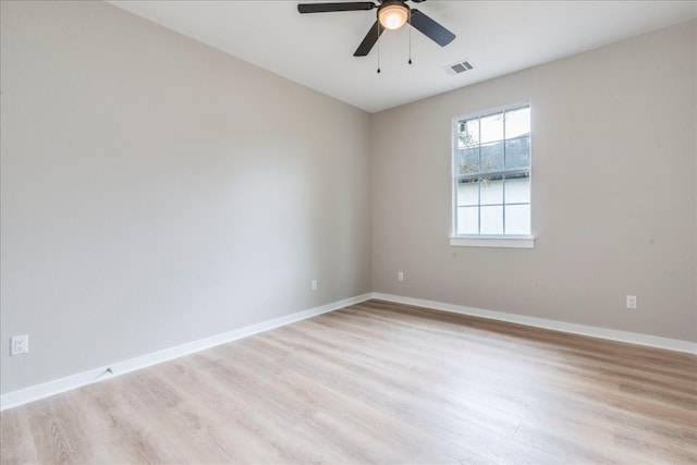 empty room with ceiling fan and light hardwood / wood-style flooring