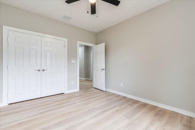 unfurnished bedroom featuring a closet, light hardwood / wood-style floors, and ceiling fan