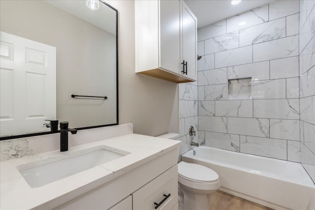 full bathroom featuring vanity, toilet, tiled shower / bath combo, and wood-type flooring