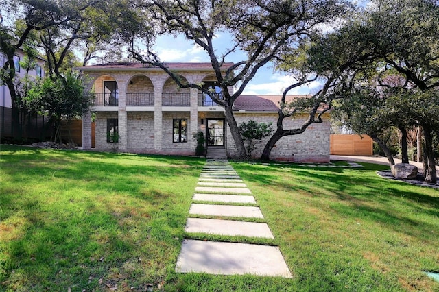 view of front facade with a balcony and a front lawn