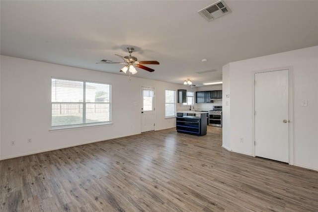 unfurnished living room with hardwood / wood-style flooring and ceiling fan