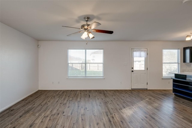 unfurnished living room featuring ceiling fan, a healthy amount of sunlight, and wood-type flooring