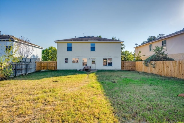 rear view of house featuring a lawn